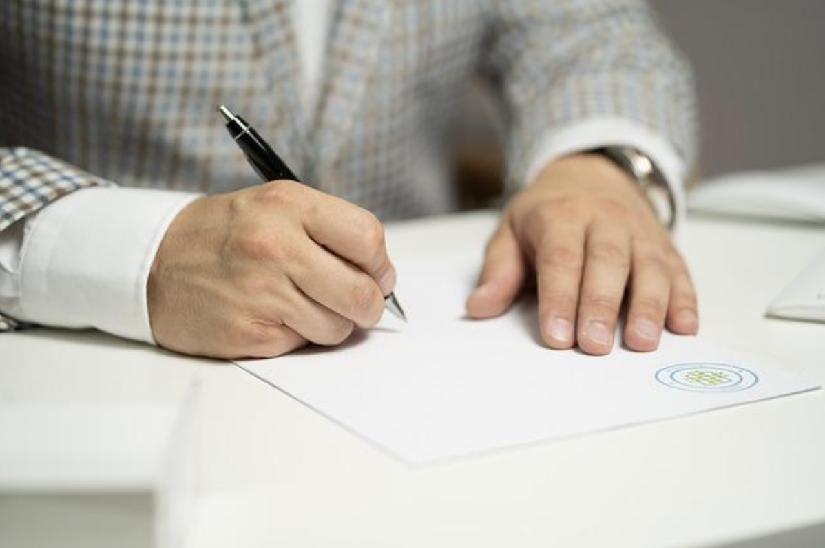 契約書と署名、契約内容を確認するルーペ